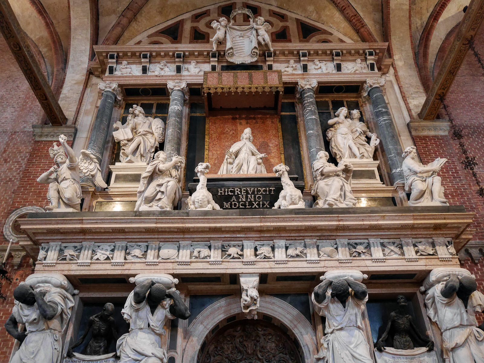 Basilica dei Frari : The mausoleum of Doge Giovanni Pesaro features four towering Moors bearing upon their shoulders the throne upon which the doge is seated next to representations of Religion, Valor, Concord, and Justice
