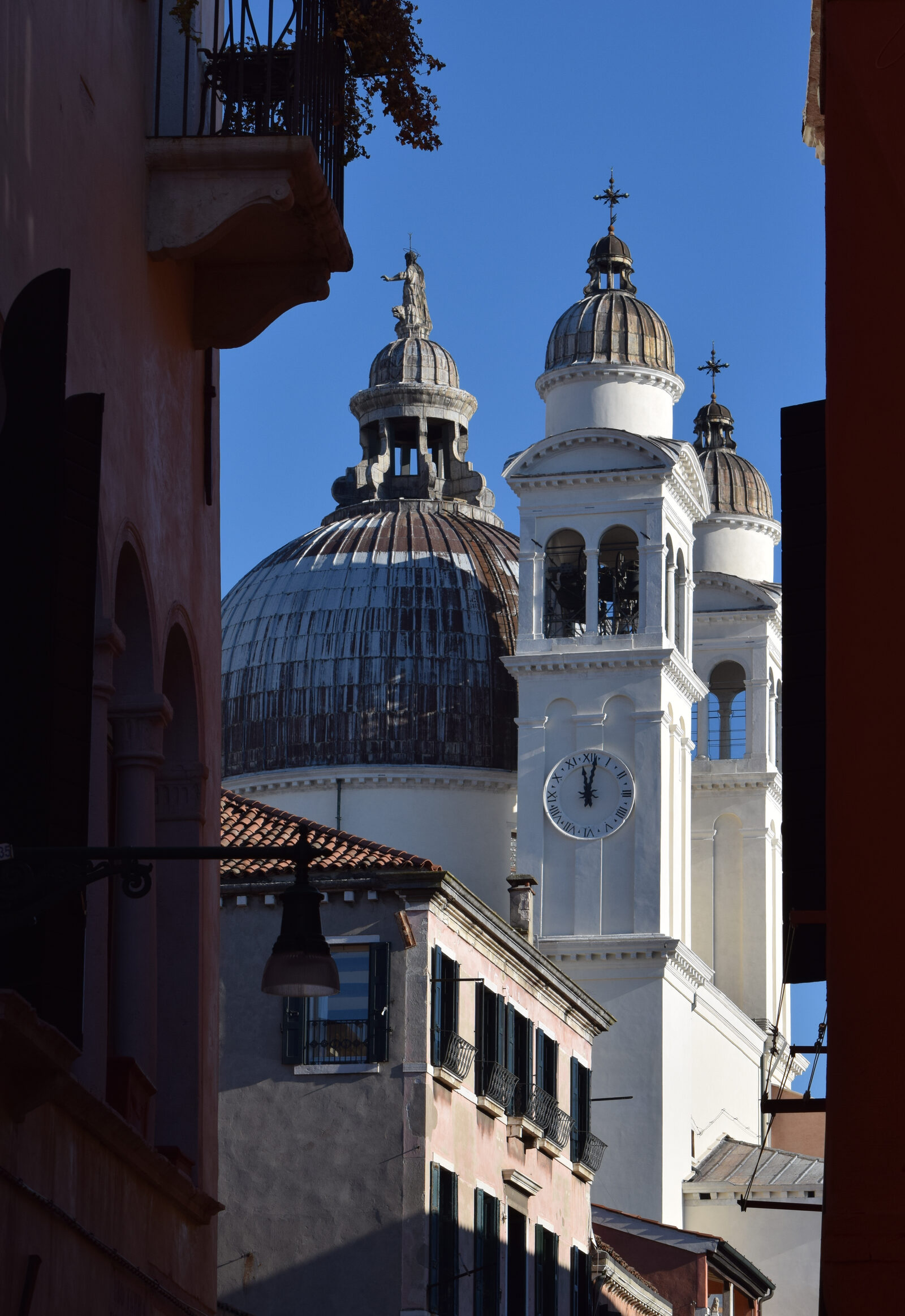 La Salute : The 2 bell towers flanking the main dome as seen from an alley in Dorsoduro