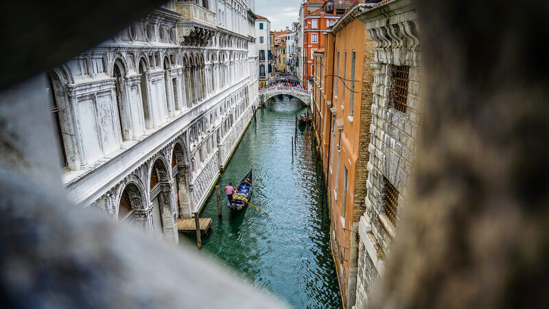 Ponte dei Sospiri : La vista dalle minuscole finestre sbarrate doveva strappare un sospiro ai prigionieri, offrendo un ultimo sguardo su Venezia, con il Ponte della Canonica sullo sfondo