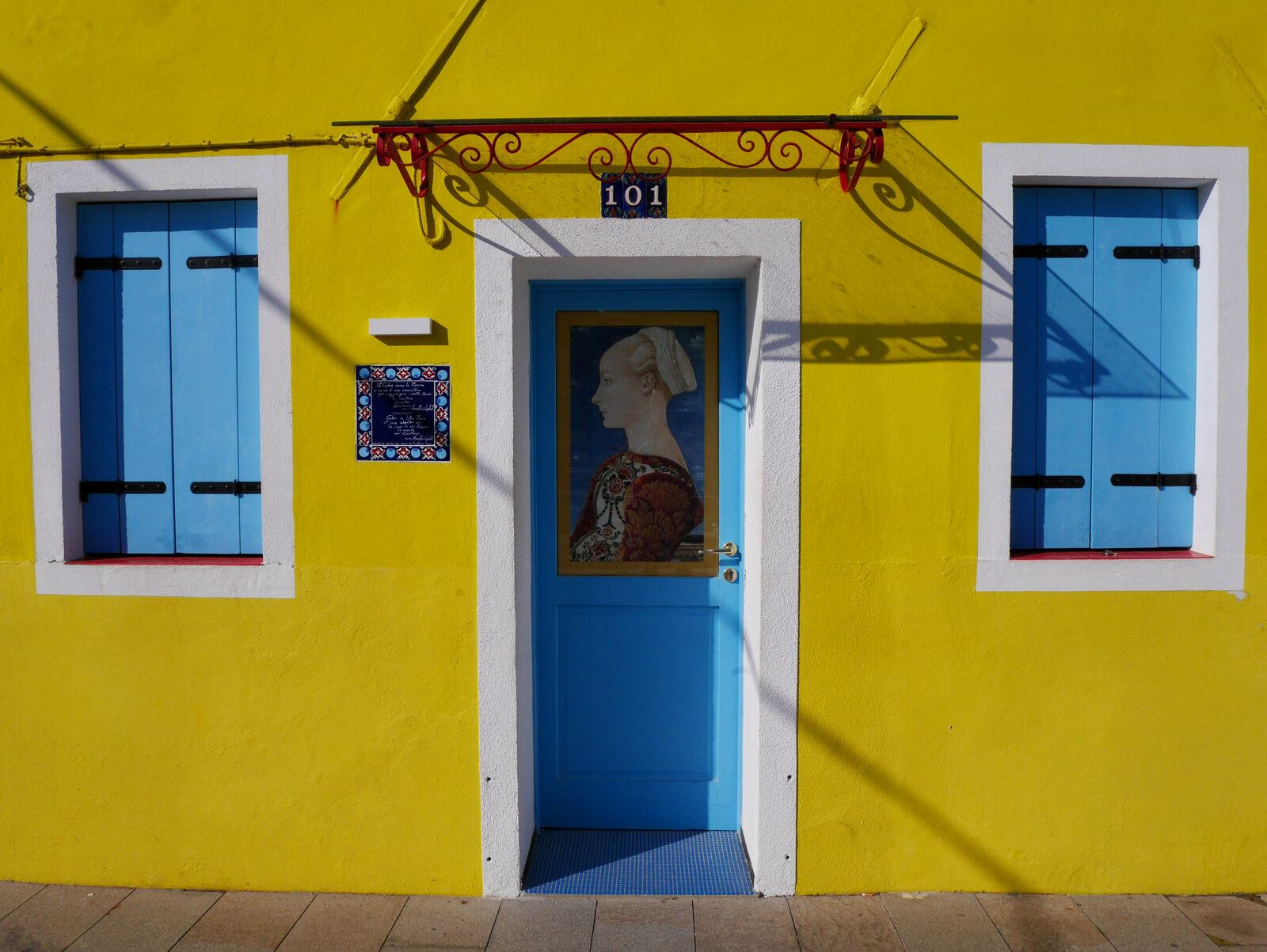 Burano : Like this striking yellow house, with a painted portrait adorning the door