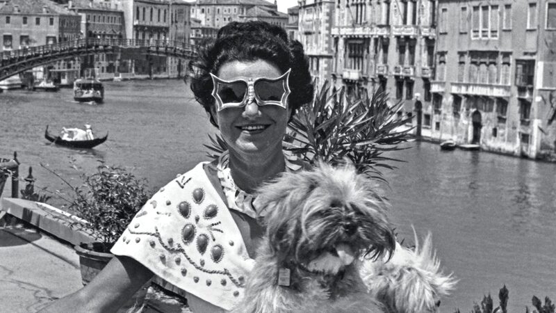 Coleção Peggy Guggenheim : Uma fotografia antiga de Peggy Guggenheim com um de seus cães, com Ponte da Accademia ao fundo