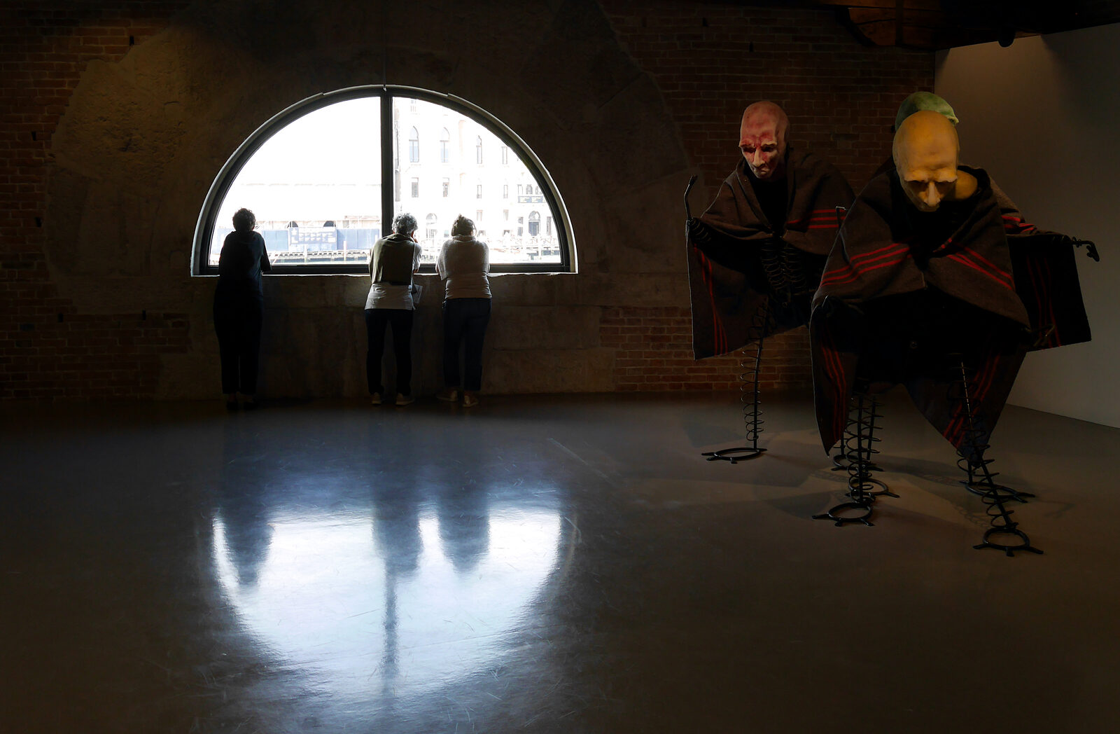 Punta della Dogana : Even amidst a captivating exhibition, visitors are drawn to the upper-level windows for the view outside.