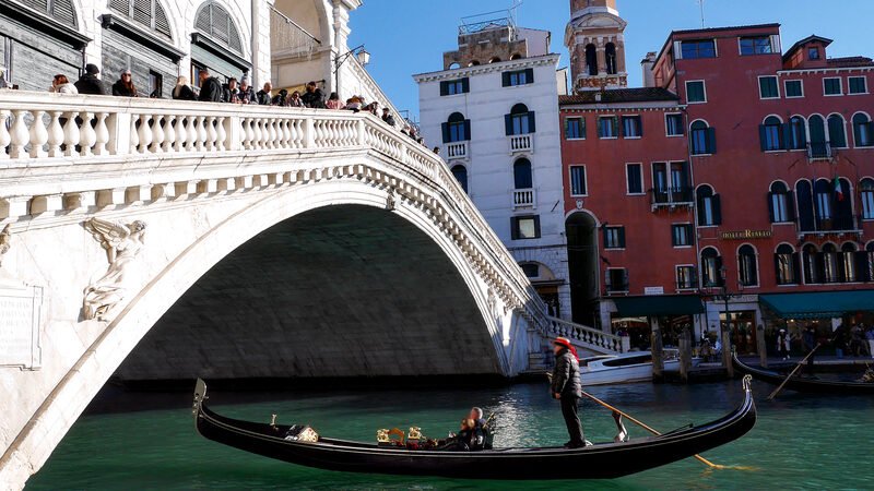 Rialto Bridge : Glide peacefully in a gondola and enjoy a brief moment of calm between the waves created by passing waterbuses