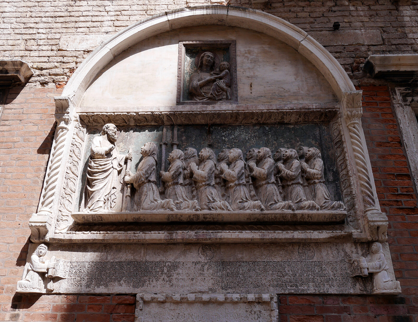 Scuola Grande San Giovanni : El bajorrelieve a la izquierda de la entrada, con los hermanos fundadores arrodillados ante San Juan