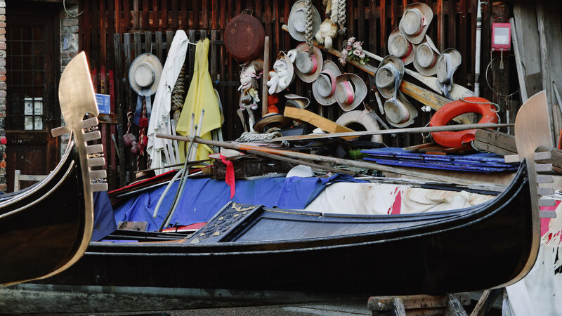 Squero di San Trovaso : Behind the gondolas in progress, the wall is lined with the gondoliers' hats
