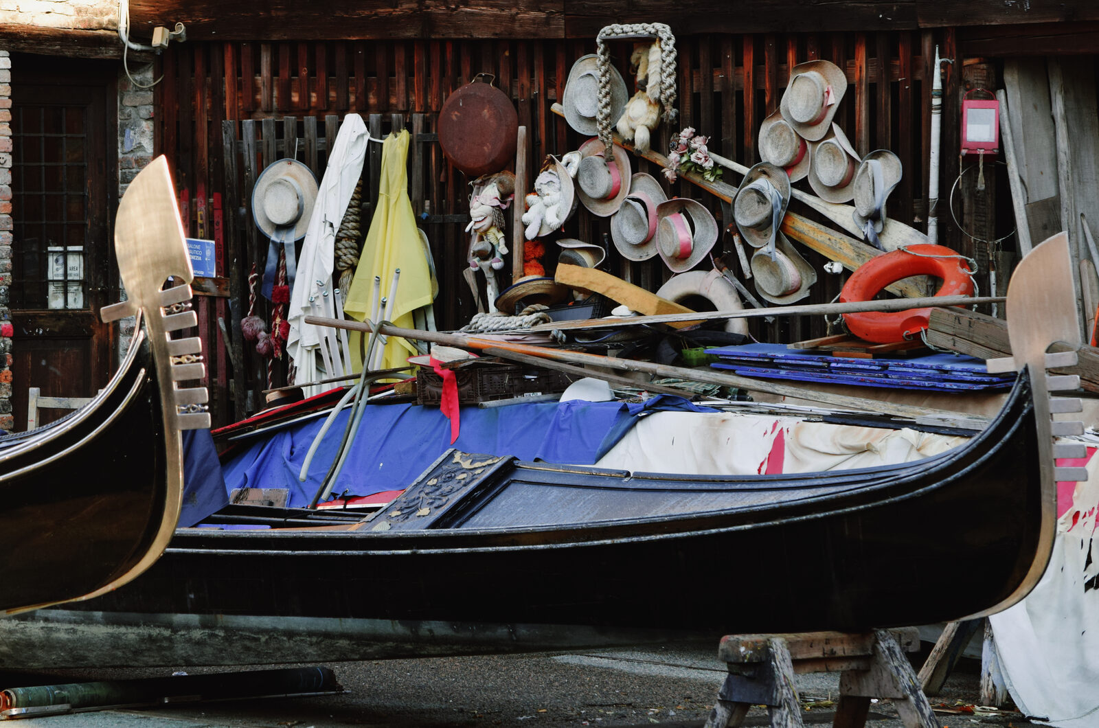 Squero di San Trovaso : Behind the gondolas in progress, the wall is lined with the gondoliers' hats